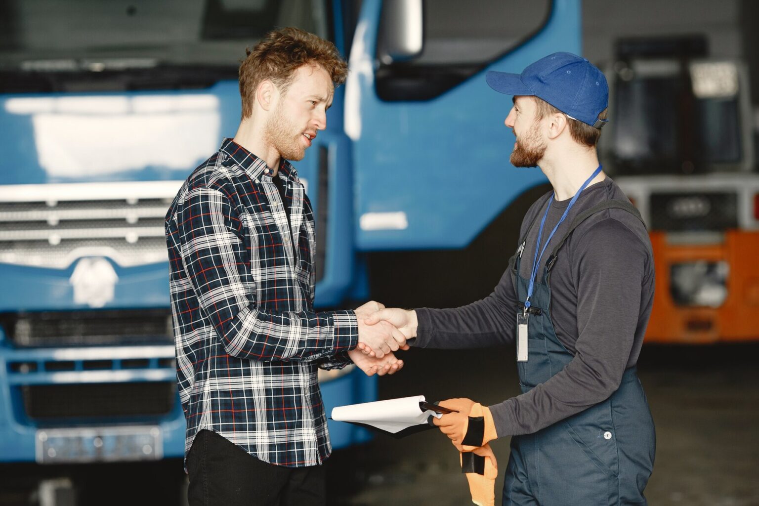 Un client et un chauffeur se saluant devant un camion de transport.